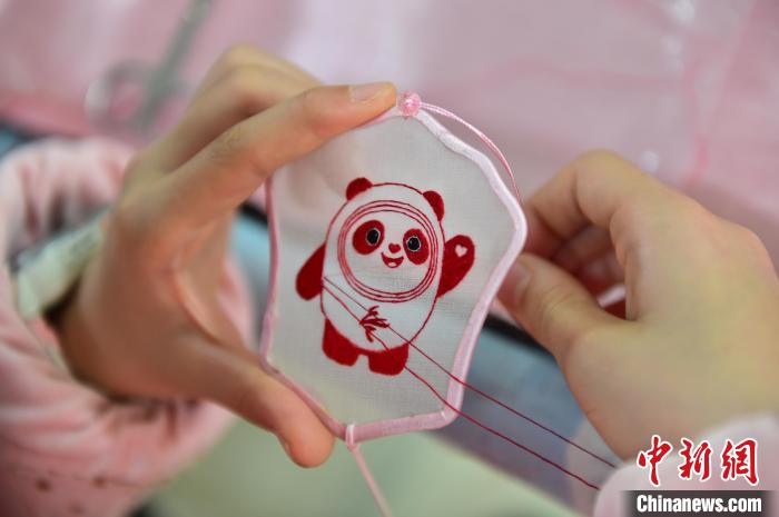 圖為一名小學(xué)生正在繡制2022年北京冬奧會吉祥物“冰墩墩”形象。　喻云亮 攝
