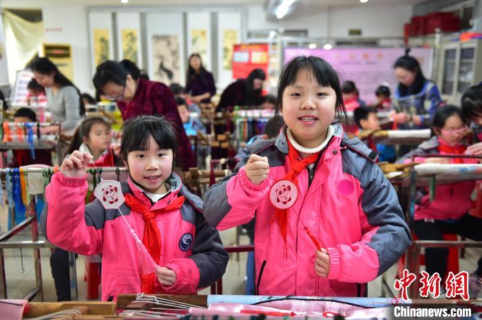 圖為小學(xué)生展示繡制好的2022年北京冬奧會吉祥物“冰墩墩”形象?！∮髟屏?攝