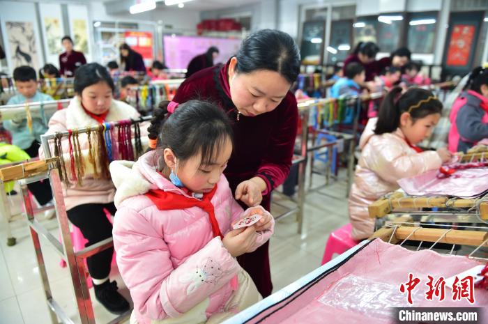 江西省級非遺豫章繡傳承人手把手指導(dǎo)小學(xué)生繡制2022年北京冬奧會吉祥物“冰墩墩”形象?！∮髟屏?攝