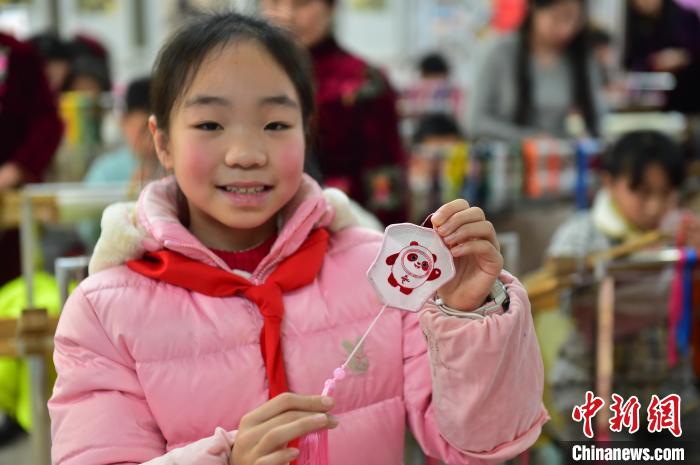 圖為一名小學(xué)生繡制的2022年北京冬奧會吉祥物“冰墩墩”形象?！∮髟屏?攝