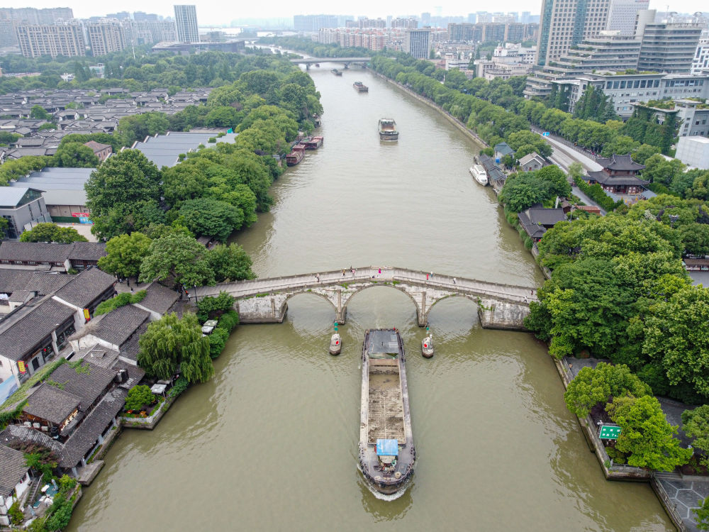 5月27日，一艘貨船駛過京杭大運(yùn)河南端標(biāo)志建筑杭州拱宸橋。(無人機(jī)照片)新華社記者江漢 攝