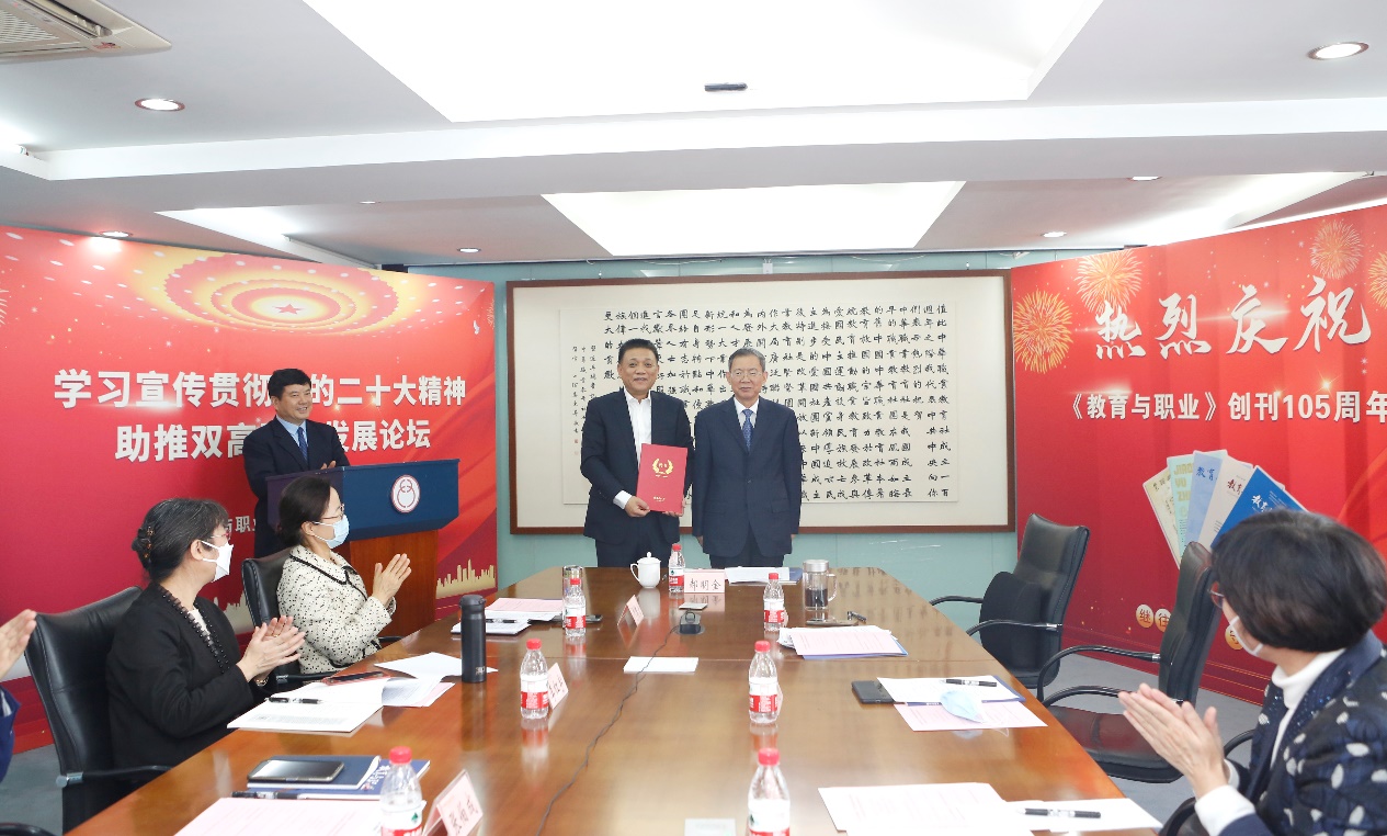 郝明金為《教育與職業(yè)》雜志編委代表陳曉明頒發(fā)聘書。中華職教社供圖