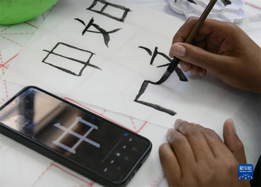 4月18日，肯尼亞學生在內(nèi)羅畢大學孔子學院舉辦的活動上寫毛筆字?？夏醽唭?nèi)羅畢大學孔子學院18日舉辦“中文，增進文明對話”主題活動，慶祝即將到來的第14個聯(lián)合國中文日。肯尼亞學生參與互動，進行書法、剪紙、唱中文歌等活動。新華社記者 韓旭 攝