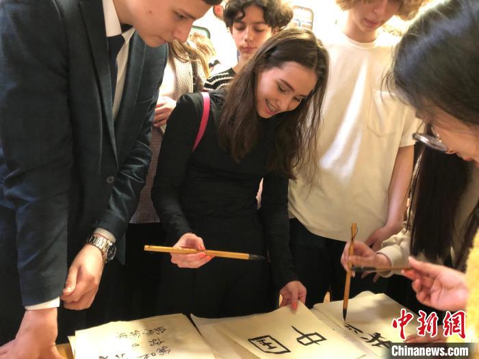 4月21日，莫斯科國立語言大學(xué)孔子學(xué)院附屬中學(xué)舉辦“國際中文日”活動(dòng)，學(xué)生們學(xué)寫漢字?！∧箍茋⒄Z言大學(xué)孔子學(xué)院 供圖