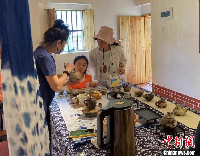 圖為：游客正在咨詢臺灣柴燒作品?！∪~秋云 攝