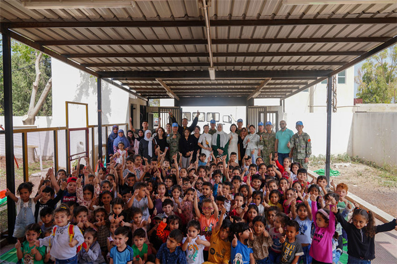 當(dāng)?shù)貢r(shí)間5月30日，黎巴嫩南部庫(kù)雷拉公立小學(xué)，“六一”國(guó)際兒童節(jié)前夕，中國(guó)第21批赴黎維和多功能工兵分隊(duì)官兵看望慰問(wèn)學(xué)校師生，并開展文化交流活動(dòng)，圖為我維和官兵同師生合影。李竹林?jǐn)z