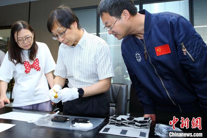科研人員查看隨神舟十五號返回地面的空間科學實驗樣品?！≈锌圃嚎臻g應(yīng)用中心 供圖