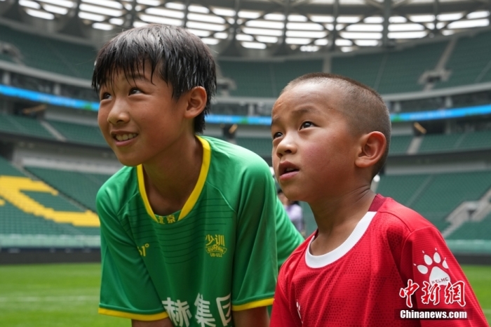 圖為北京國(guó)安小球員陳小北和7歲的俄金仁增在一起觀看場(chǎng)內(nèi)播放的紀(jì)錄片。<a target='_blank' href='/' _fcksavedurl='/'><p  align=