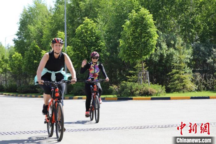 亞信副秘書長遲方(右一)與聯(lián)合國駐哈協(xié)調(diào)員在騎行活動中。　亞信秘書處供圖