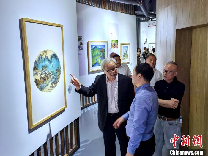 海峽兩岸藝術(shù)家畫(huà)展上，藝術(shù)家進(jìn)行藝術(shù)交流?！「毒窜?攝