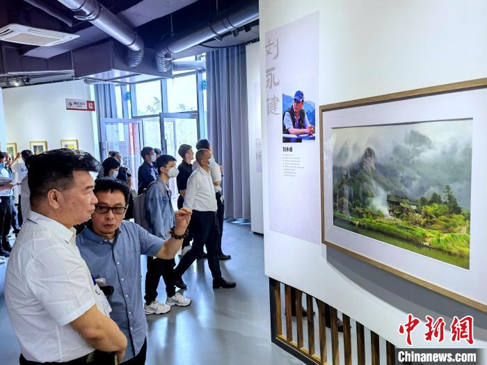 海峽兩岸藝術(shù)家畫(huà)展上，藝術(shù)家進(jìn)行藝術(shù)交流?！「毒窜?攝