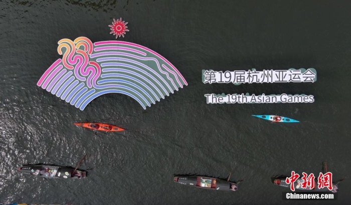 資料圖為烏篷船和皮劃艇從杭州亞運會標(biāo)識前劃過。王剛 攝