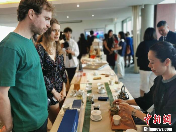 現(xiàn)場(chǎng)觀眾觀看中國(guó)展臺(tái)茶藝表演、了解茶文化。　靖樹(shù) 攝
