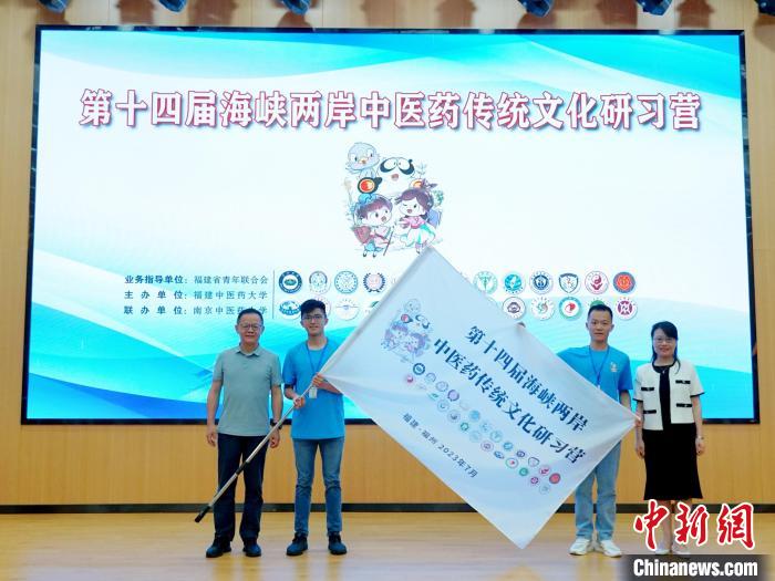共青團(tuán)福建省委副書記吳雪(右一)、福建中醫(yī)藥大學(xué)黨委副書記林羽(左一)為兩岸學(xué)生代表頒授營旗?！≡S燁婷 攝
