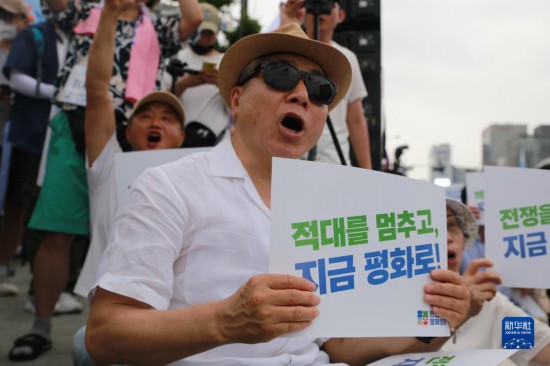 7月22日，在韓國(guó)首爾，人們手舉標(biāo)語(yǔ)參與反戰(zhàn)游行。新華社發(fā)（楊暢 攝）