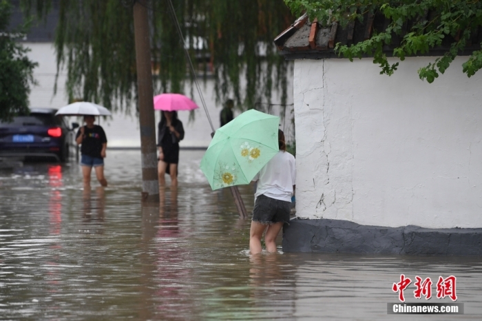 7月31日，市民行走在雨中的北京房山區(qū)瓦窯頭村。北京市氣象臺當(dāng)日10時發(fā)布分區(qū)域暴雨紅色預(yù)警信號。北京市水文總站發(fā)布洪水紅色預(yù)警，預(yù)計當(dāng)日12時至14時，房山區(qū)大石河流域?qū)⒊霈F(xiàn)紅色預(yù)警標(biāo)準(zhǔn)洪水。<a target='_blank' href='/'><p  align=