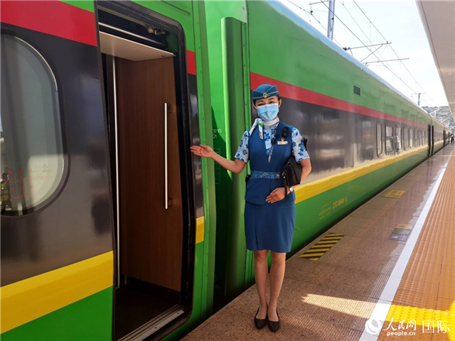 趙瑩靜站在“復(fù)興號(hào)”國(guó)際旅客列車(chē)車(chē)廂門(mén)口歡迎旅客上車(chē)。人民網(wǎng) 杜明明攝