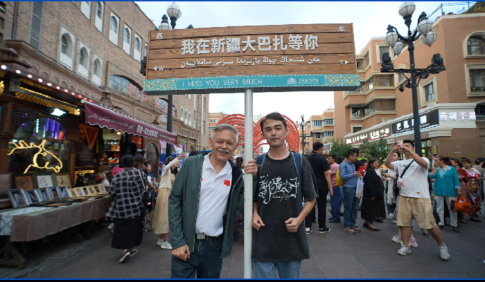 潘維廉和維吾爾族青年伊木蘭“打卡”大巴扎。主辦方供圖