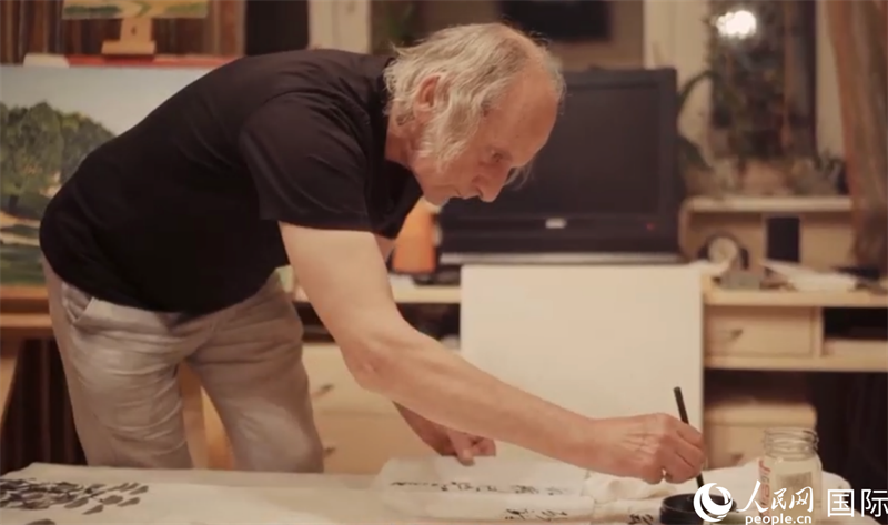 伊戈?duì)枴げ紶枛|諾夫在畫作上題詞。人民網(wǎng)記者 馬天翼攝