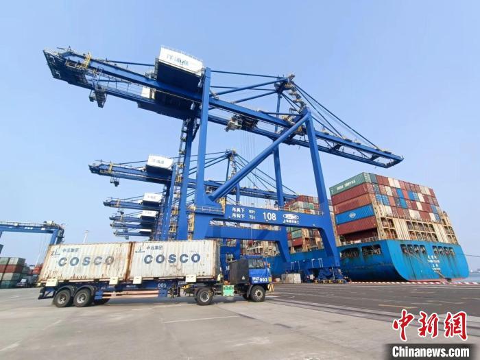 圖為海南洋浦國際集裝箱碼頭，卡車將集裝箱從后方堆場運(yùn)往碼頭裝卸區(qū)?！?jiān)潞?攝