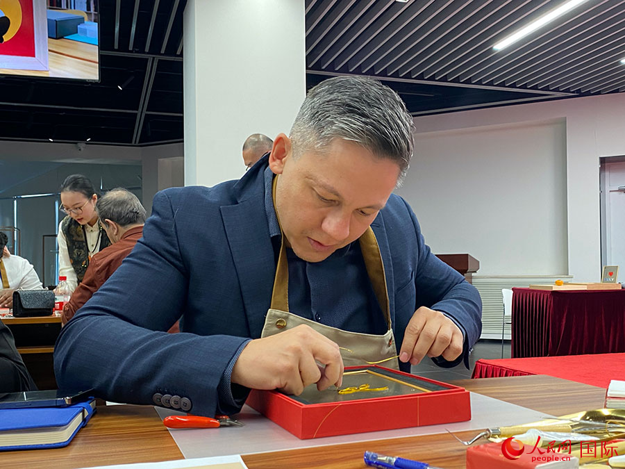 2023“一帶一路”媒體合作論壇聯(lián)合采訪團團員，親身體驗景泰藍(lán)工藝。人民網(wǎng)記者 于洋攝