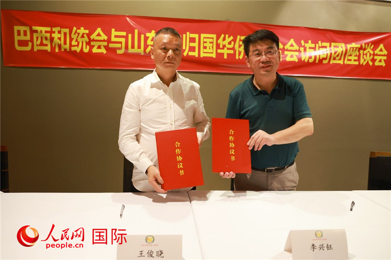 中國僑聯(lián)副主席、山東省僑聯(lián)主席李興鈺（右）與巴西和統(tǒng)會會長王俊曉簽署合作協(xié)議書。人民網(wǎng)記者 陳海琪攝