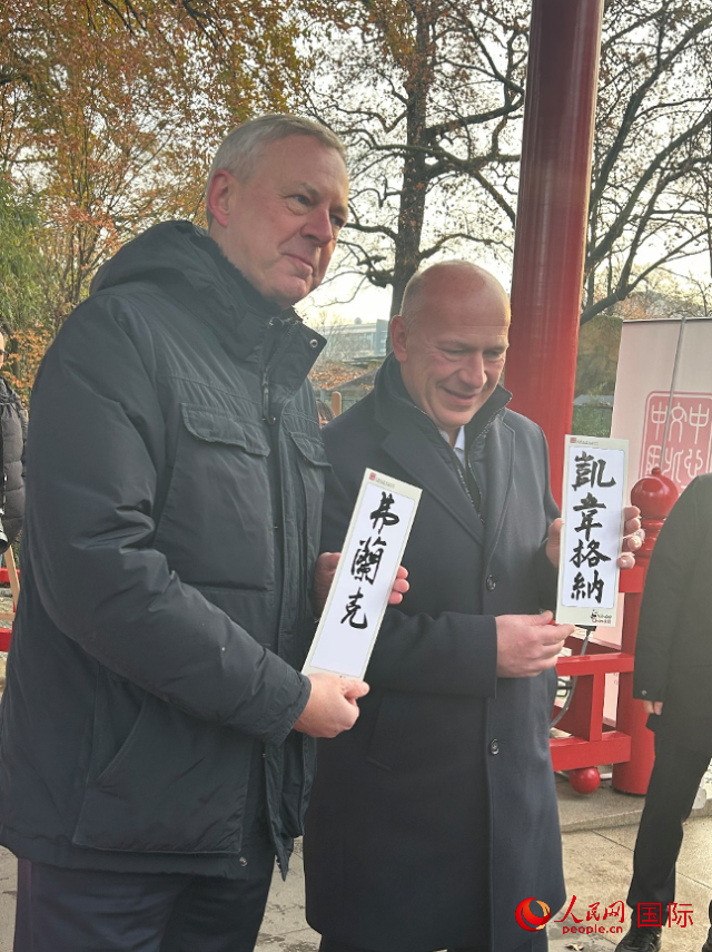 柏林市長(zhǎng)韋格納（右）、動(dòng)物園監(jiān)事會(huì)主席布魯克曼（左）手持中國文化中心工作人員現(xiàn)場(chǎng)手書的中文名字。人民網(wǎng)記者 徐馨攝