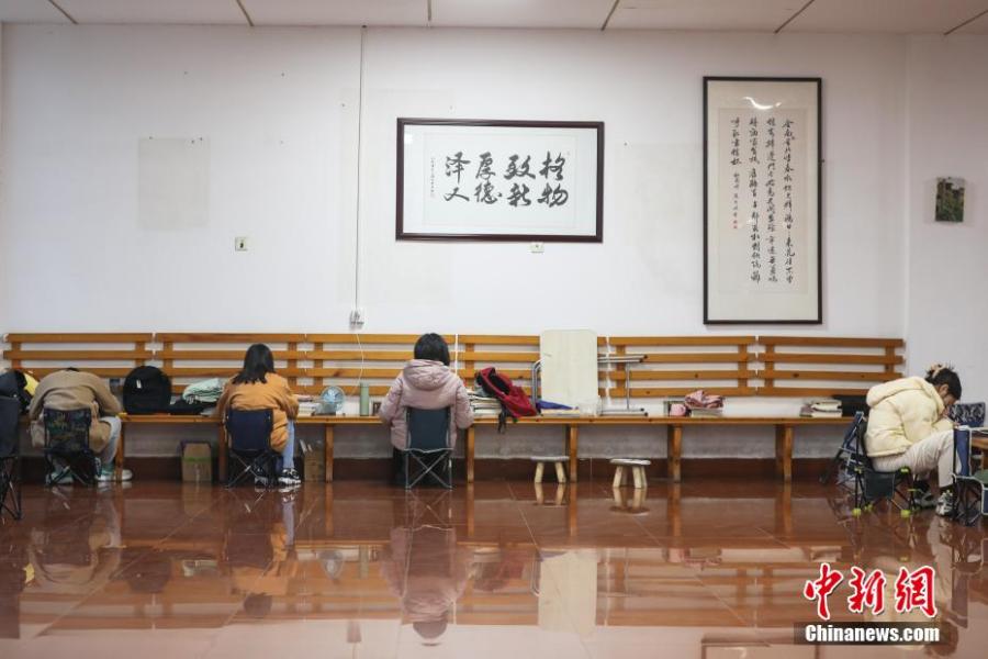 資料圖：幾位考研學(xué)生在南昌大學(xué)教學(xué)樓的公共空間復(fù)習(xí)備考。劉力鑫 攝