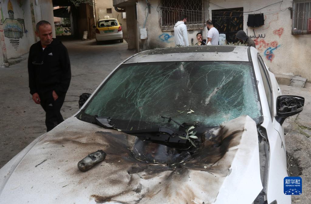 12月17日，在約旦河西岸城市圖勒凱爾姆附近的一處難民營，人們查看在沖突中損毀的車輛。新華社發(fā)（尼達(dá)爾·艾仕塔耶?dāng)z）