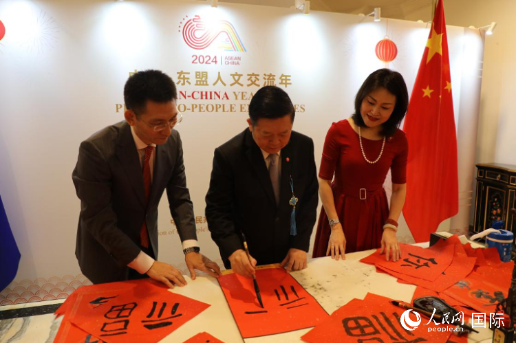 東盟秘書長高金洪（中）在活動現(xiàn)場寫福字。人民網(wǎng)記者曹師韻攝