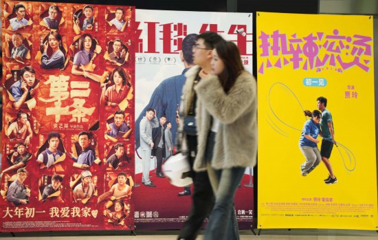 這是2月17日，在沈陽一家影院，觀眾從海報(bào)前經(jīng)過。新華社記者李鋼攝