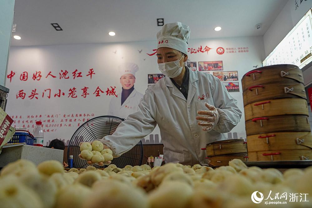 3月31日，在浙江省嵊州市甘霖鎮(zhèn)，嵊州小吃從業(yè)者沈紅平把蒸熟的小籠包晾涼，打包冷藏售賣。人民網(wǎng) 章勇濤攝