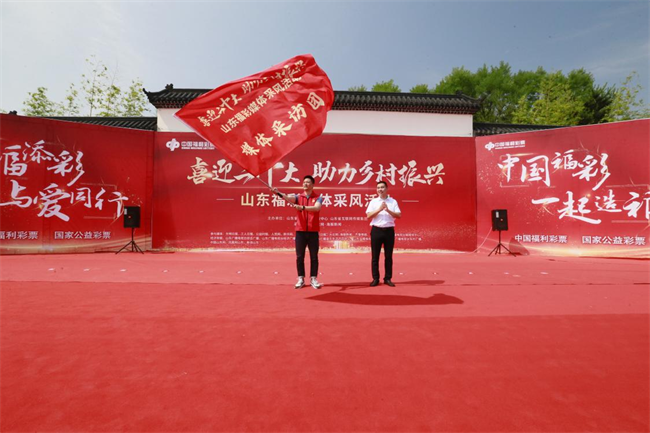 為媒體采風(fēng)團(tuán)授旗。 山東省福彩供圖