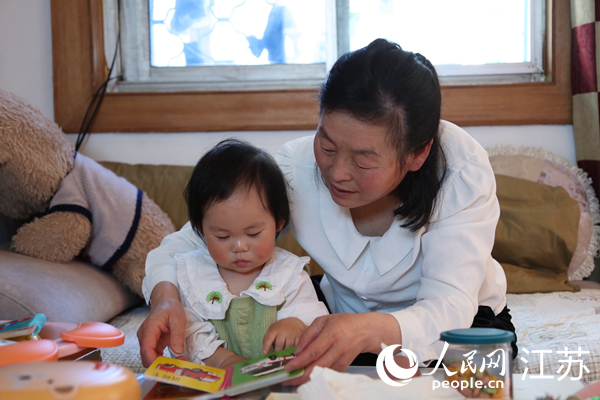 王繼蓮帶孫女看童書。人民網(wǎng) 冷金明攝