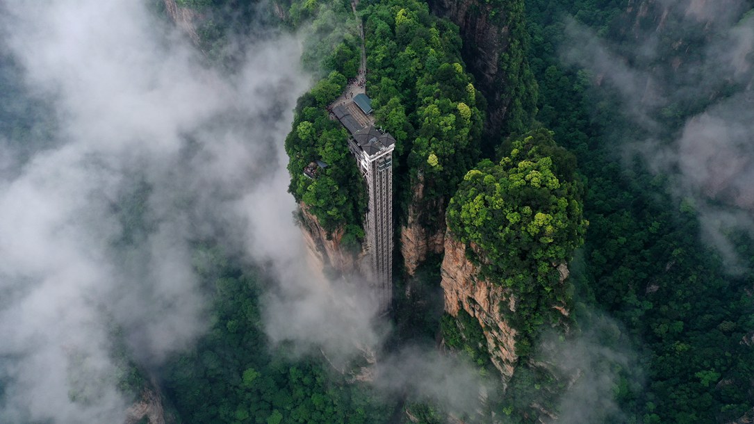 位于張家界武陵源景區(qū)的百龍?zhí)焯蓁偳对谠旗F繚繞的峰林間，雄偉壯觀。吳勇兵攝