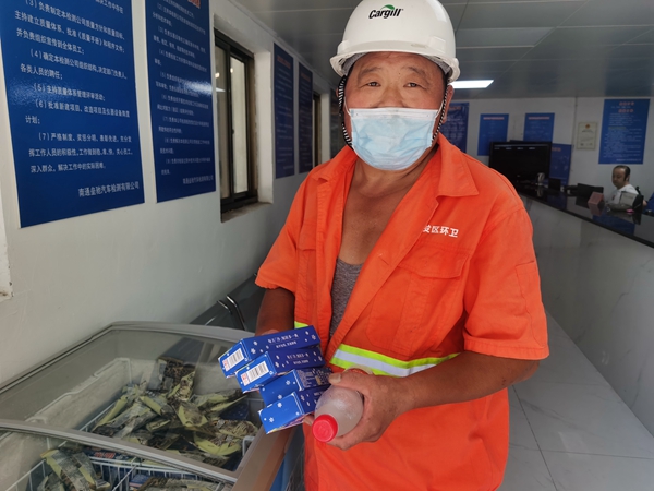 1環(huán)衛(wèi)工倪建宏小憩后，為還同事帶去冷飲。人民網記者王繼亮攝