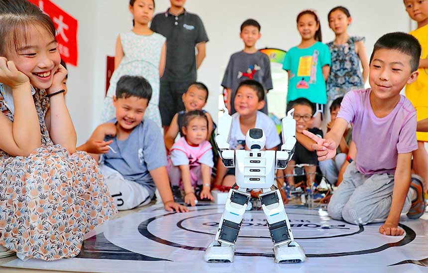 2022年7月19日，河北省秦皇島市海港區(qū)白塔嶺街道秦皇半島第二社區(qū)內，小朋友正在觀看“機器人跳舞”。 曹建雄攝