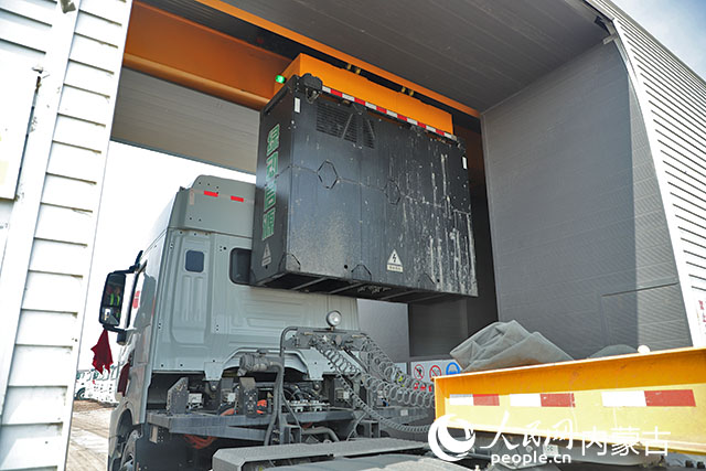 萬利新能源數(shù)字陸港里，正在充換電站進(jìn)行換電的重卡。人民網(wǎng)記者 趙夢月攝