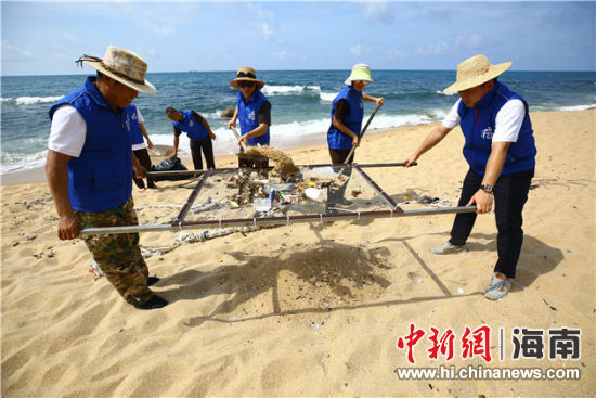 環(huán)保志愿者用篩網(wǎng)“淘”出海灘上的垃圾。