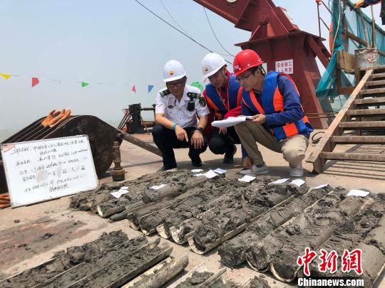 圖為勘察設(shè)計(jì)人員與海事局工作人員查看巖芯情況?！∥赫?攝