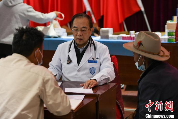 北京大學人民醫(yī)院心臟中心副主任、博士生導師王偉民為農牧民問診。　江飛波 攝
