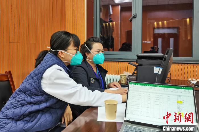 8月9日，楊蘇喬(左)在拉薩方艙醫(yī)院指揮部讀取艙內(nèi)患者胸部CT。　受訪者供圖