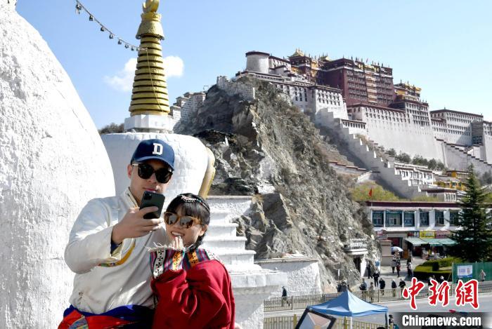 4月17日，游客身著藏式元素服裝在拉薩布達(dá)拉宮觀景臺(tái)拍照留念?！±盍?攝