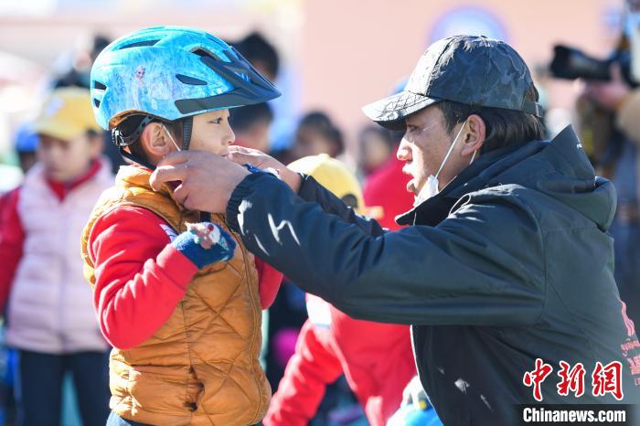 圖為拉薩市實驗幼兒園孩子在教練的幫助下穿戴頭盔?！『闻罾?攝