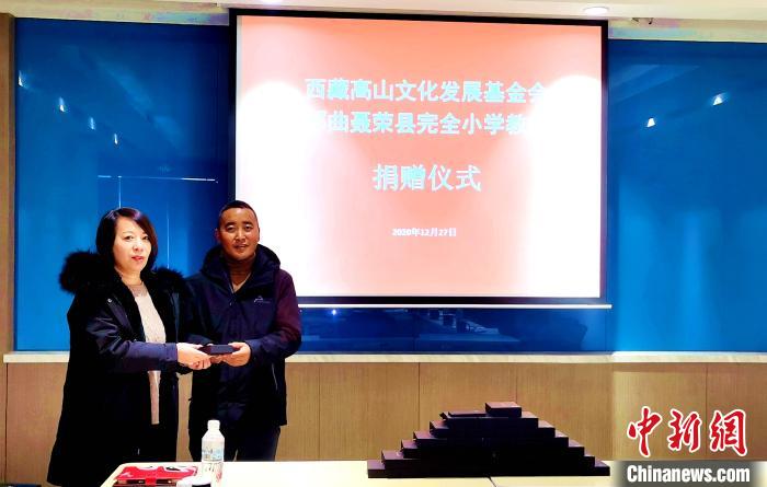 圖為西藏高山文化發(fā)展基金會理事長溫麗向聶榮縣完全小學(xué)負責(zé)人捐助儀器。　于賓 攝