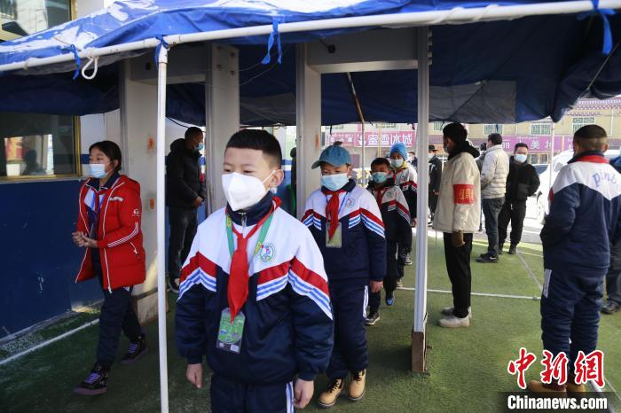 圖為學(xué)生測量體溫后進入校園?！●R銘言 攝