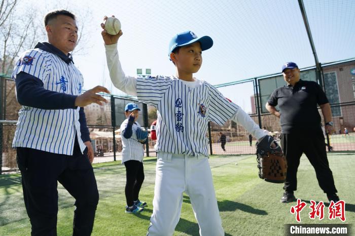 圖為教練指導(dǎo)小棒球手?jǐn)S球技術(shù)?！●R銘言 攝