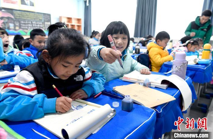 3月14日，西藏拉薩市第一小學(xué)一年級(jí)六班學(xué)生白瑪朗珍(圖左)在藏語(yǔ)文課上書(shū)寫(xiě)藏文。　李林 攝