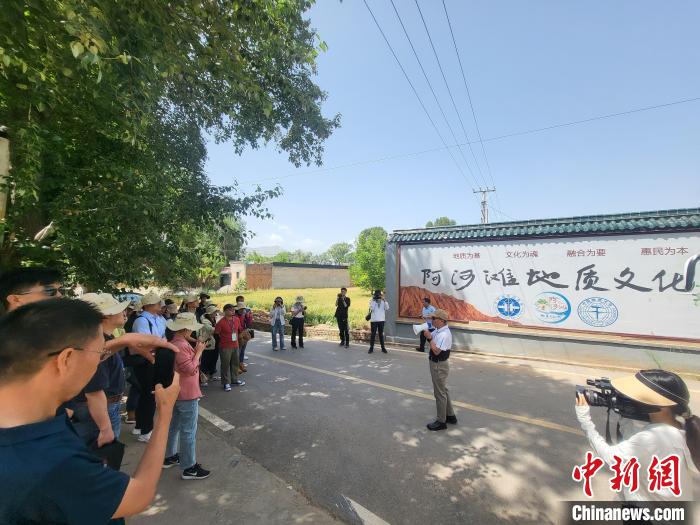 圖為中國地質(zhì)大學(北京)教授張緒教介紹村落情況?！『衍?攝