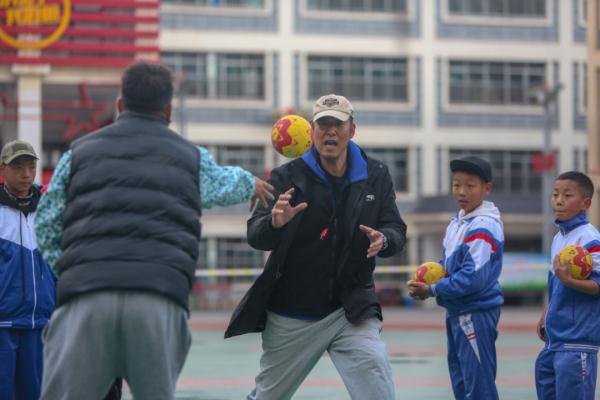 在高原上教孩子們打手球，“慢慢兒來，甭著急！”